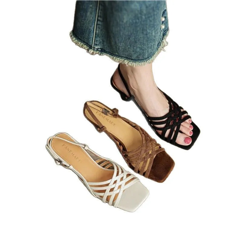 Light brown women's sandals with thin cross-straps, an ankle buckle, and a 3-6cm mid heel on a wooden floor.