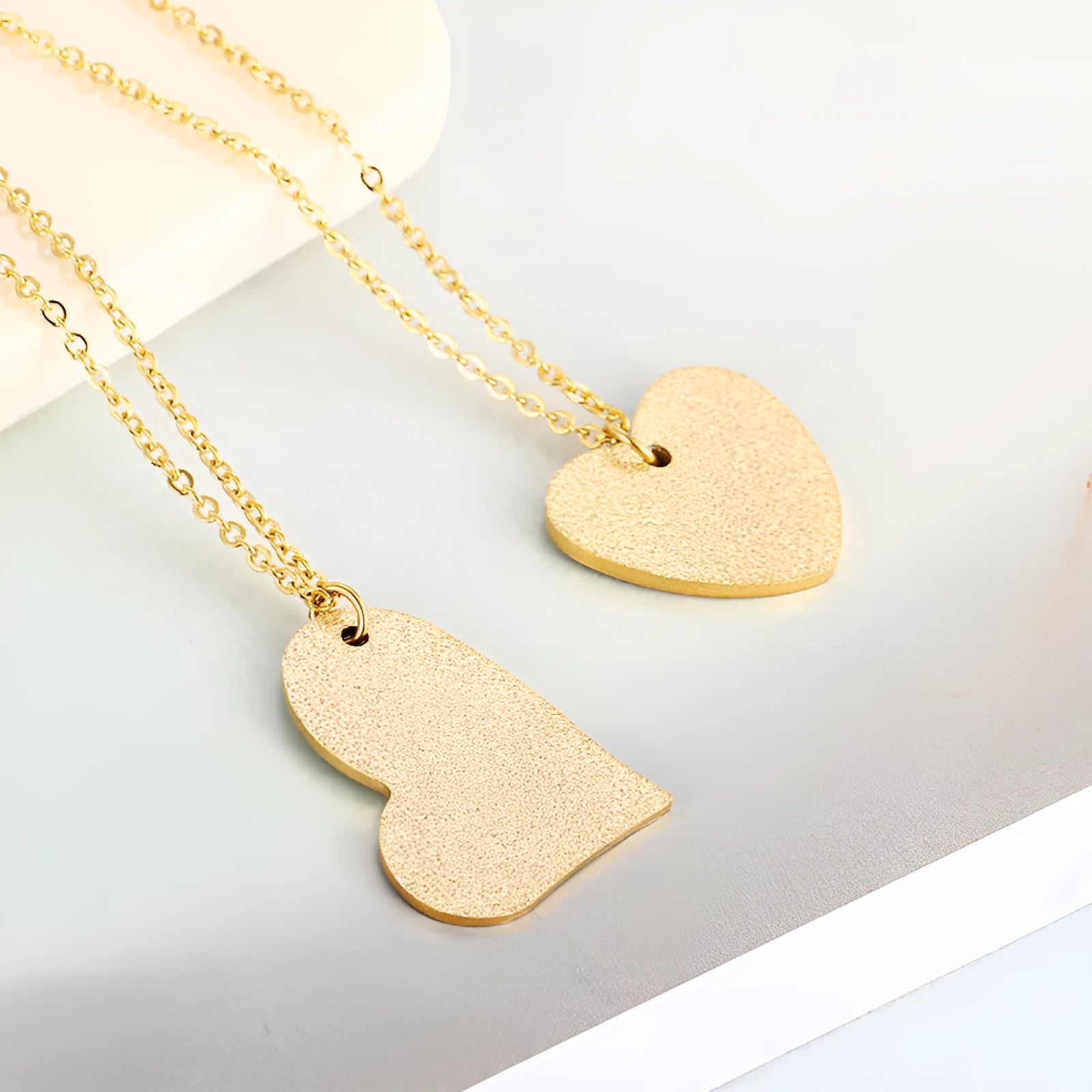 A geometric heart-shaped blue titanium steel pendant necklace on a chain.