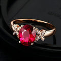 Women's butterfly-shaped ring with heart crystal in rose gold plating on blue or red background