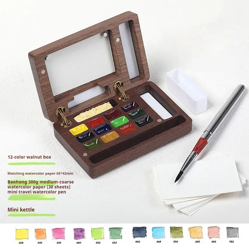 Mini wooden watercolour paint box with walnut finish, open to show pigment suit selection.