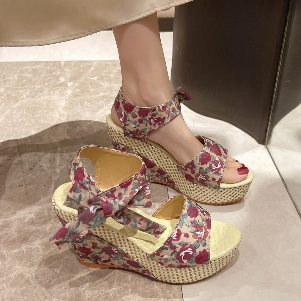 Women's floral wedge sandals with peep toe and adjustable ankle strap buckle.