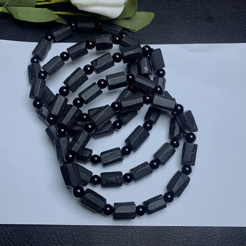 Black tourmaline rough stone bracelet on a wrist, showing natural texture and 10mm size