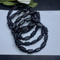 Black tourmaline rough stone bracelet on a wrist, showing natural texture and 10mm size
