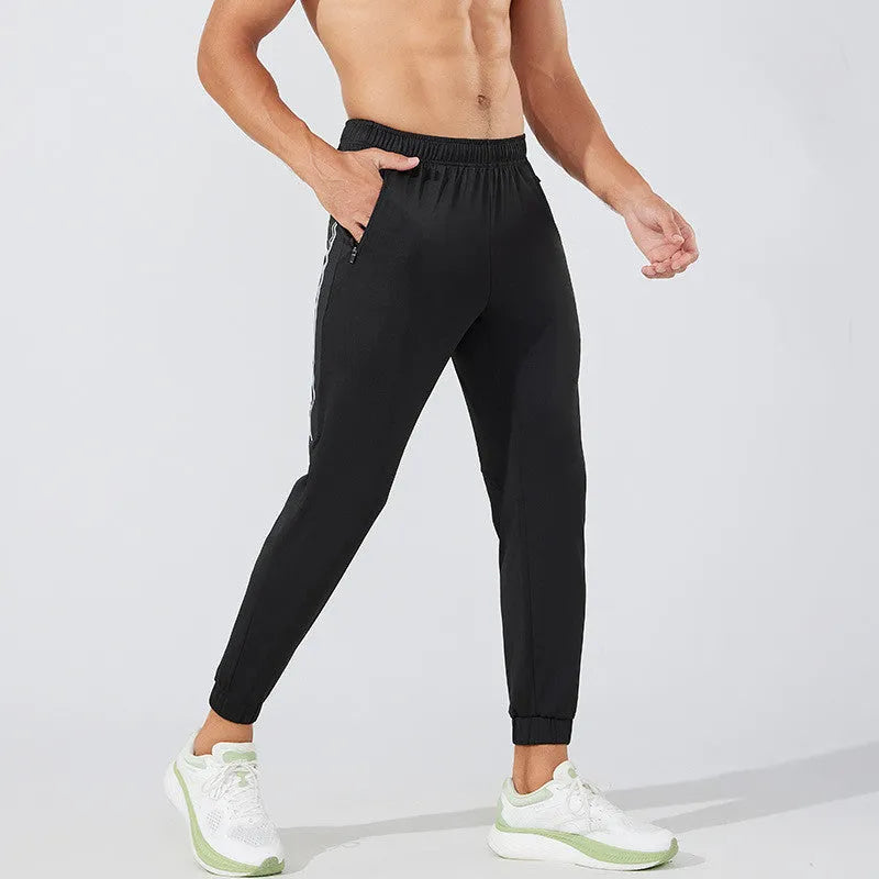 Men's black breathable polyester running trousers with mid-waist fit on a plain background.