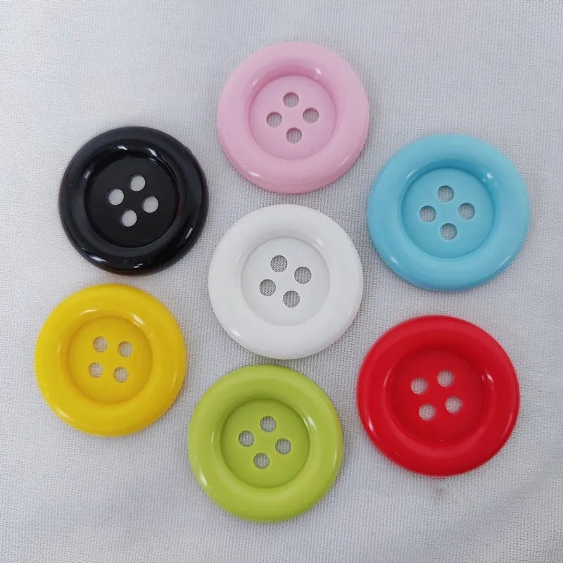 Oversized round edge plastic button with four holes in various colours and diameter sizes