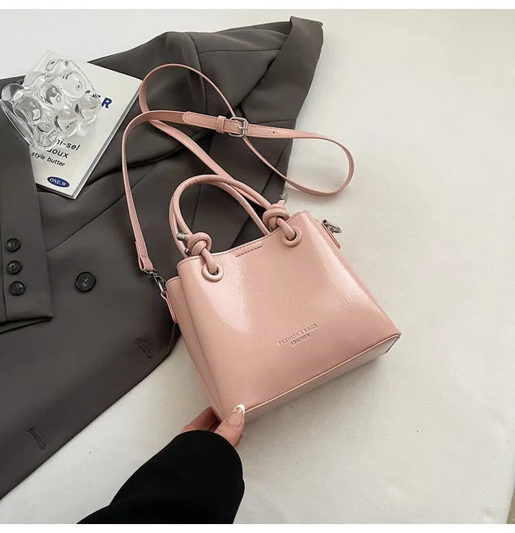 Women's medium-soft PU messenger bag in bucket shape with pendant, black, white, wine red, and pink options