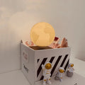 Maglev floating LED night light with planet design and three astronaut figures on display