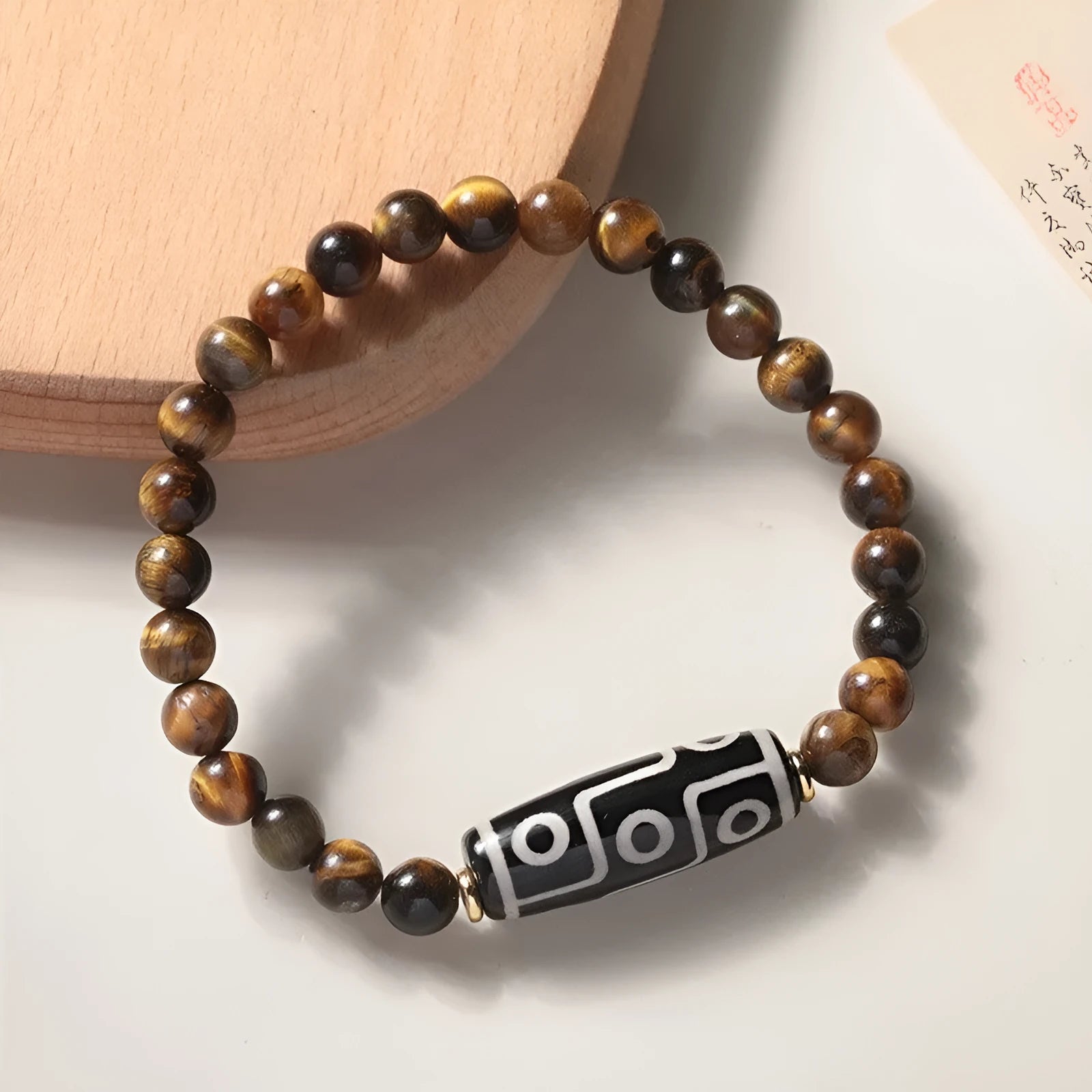 Single circle ethnic Tigereye bead Buddha rosary bracelet on a wrist, showing unisex design.