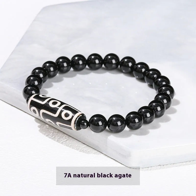 Handmade green dzi bead barrel bracelet with 8mm round geometric beads on a wrist.