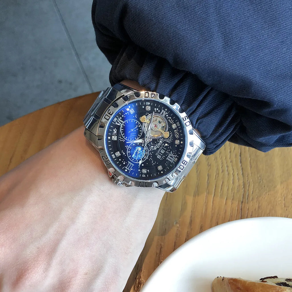 Men's silver automatic mechanical watch with black starry dial on leather strap showing transparent case back