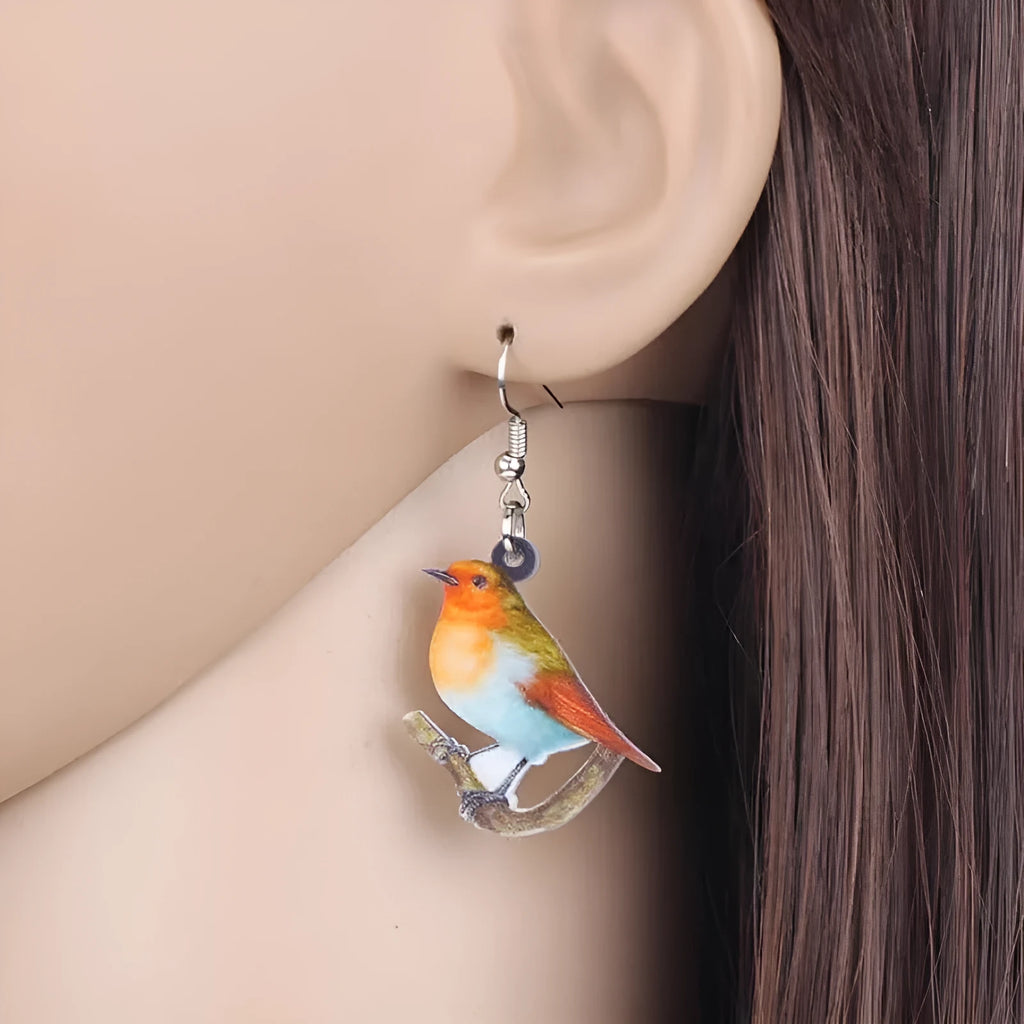 Blue Titmouse and snake motif acrylic drop earrings with geometric pendant shape on a white background.