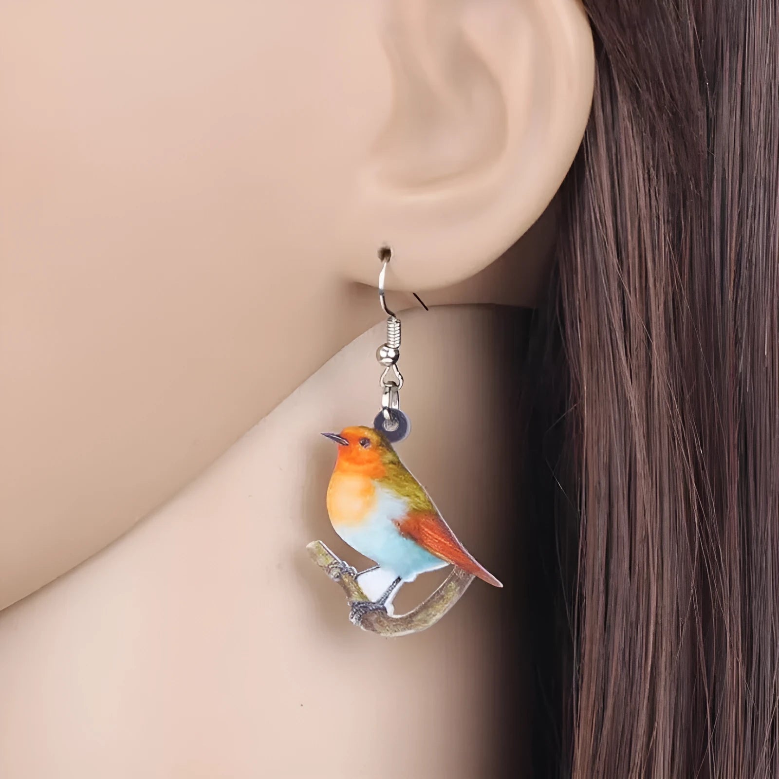 Blue Titmouse and snake motif acrylic drop earrings with geometric pendant shape on a white background.