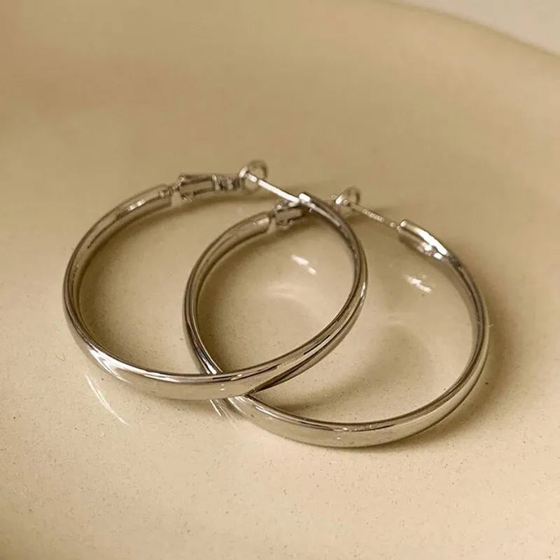 Large circular gold and silver metal hoop earrings measuring 40mm
