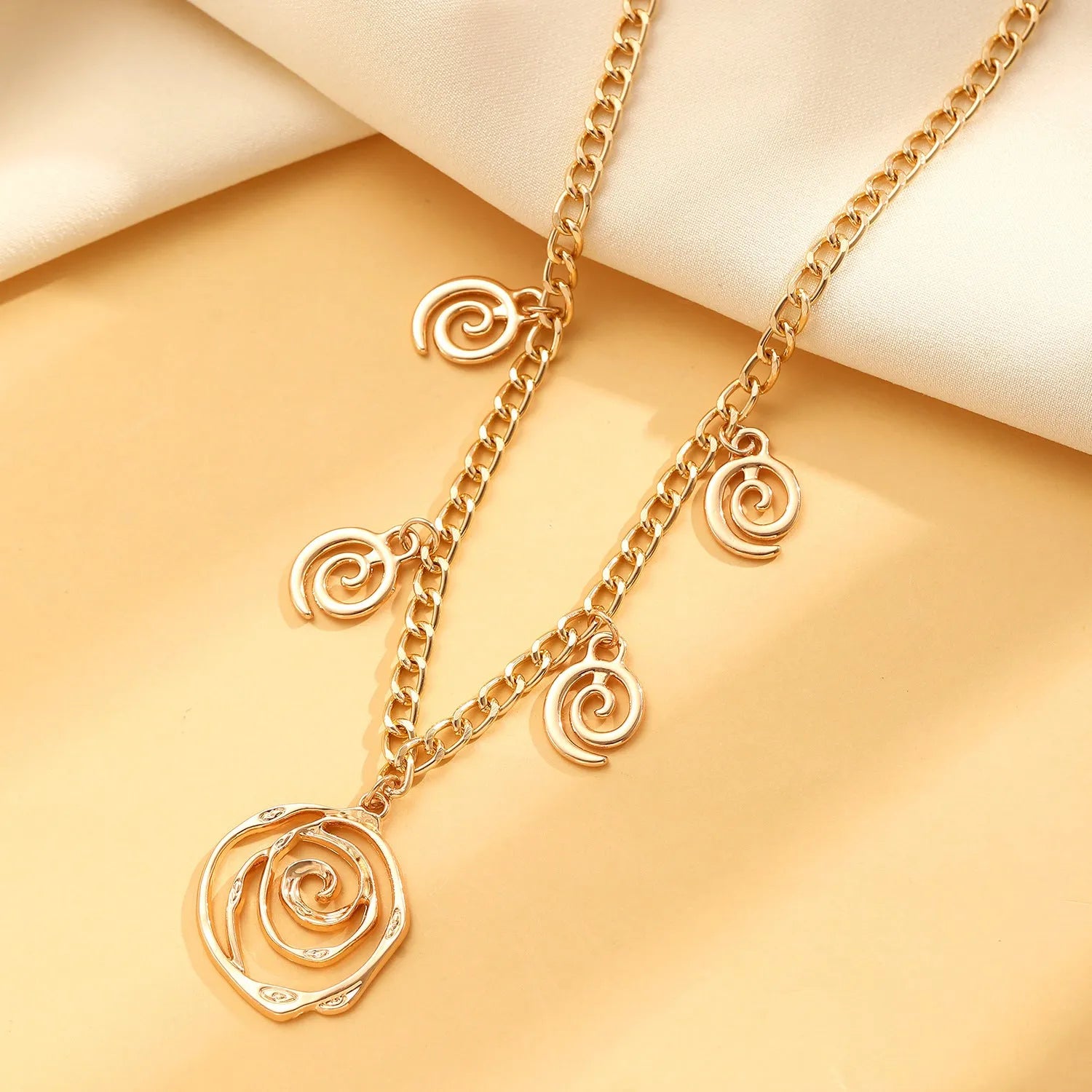 Spiral donut geometric jewellery set with necklace, bracelet, and earrings in gold electroplate