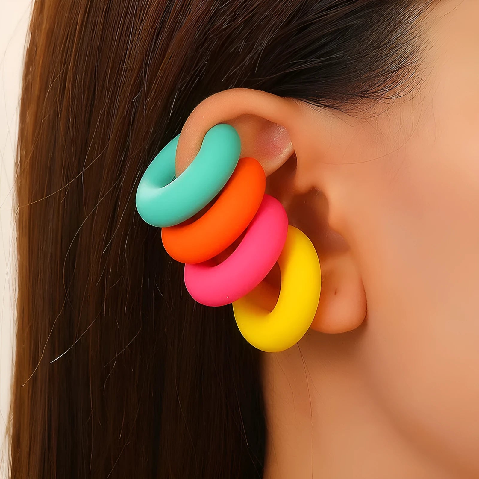 Close-up of a pair of matte coarse round C-shaped clip-on earrings for women in a candy colour.