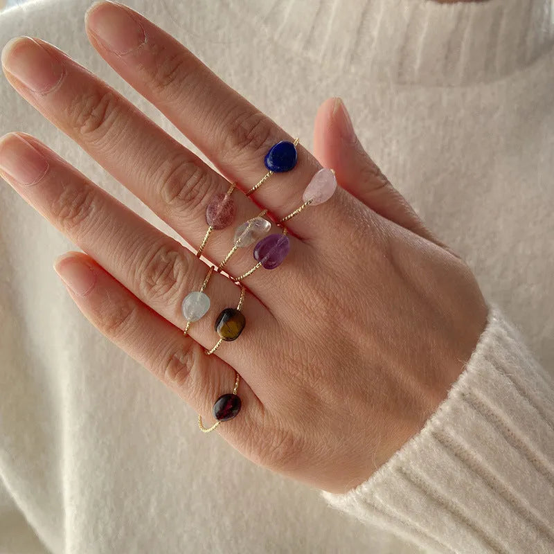 Original geometric design women's ring in coloured agate stone on a plain background.