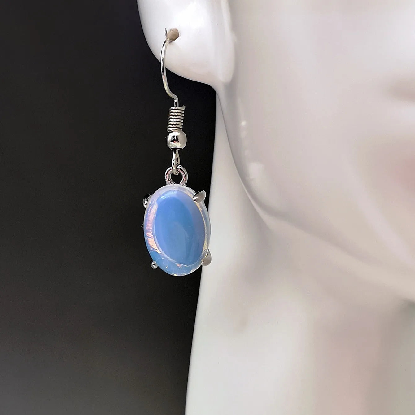 A pair of white opal-coloured drop earrings with a retro cross design on an alloy pendant.