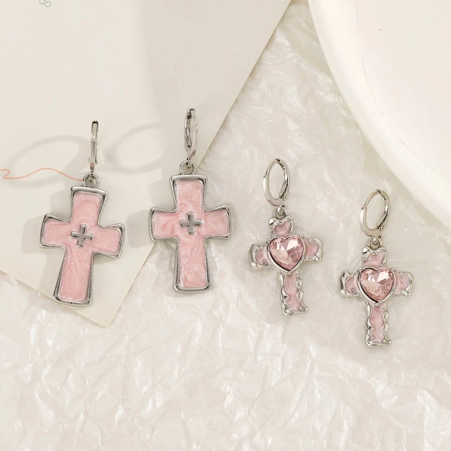 Women's classic alloy earrings with cross crystal design in five colour options on display