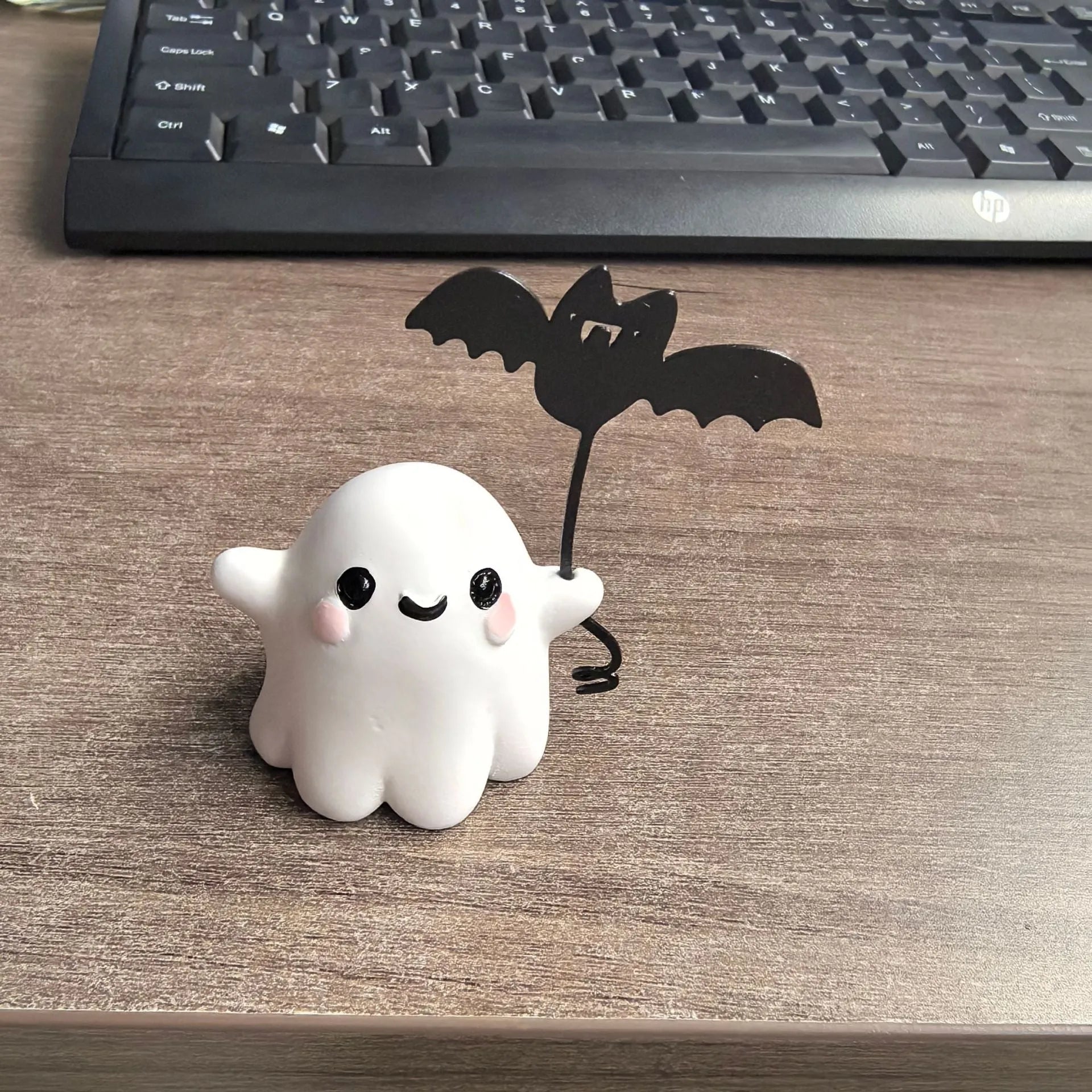 Mini resin statue of a white ghost walking a black bat, Halloween decoration