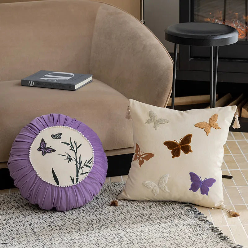 Square beige cushion with colourful embroidered butterfly and Chinese floral pattern.