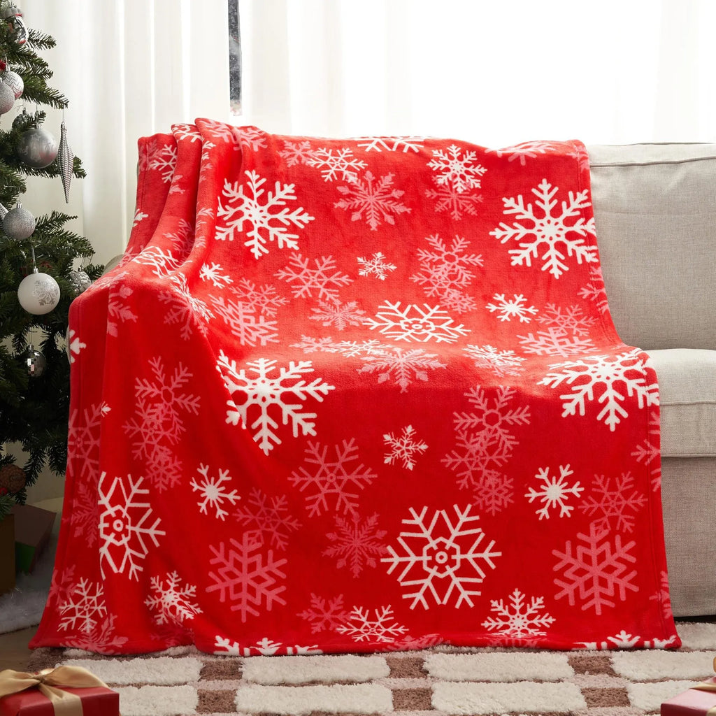 Soft plush red Christmas blanket draped over a grey sofa.