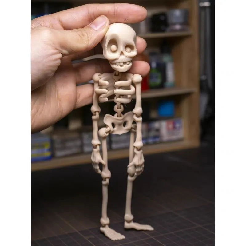 3D printed white skull refrigerator magnet with intricate details on a metallic surface.