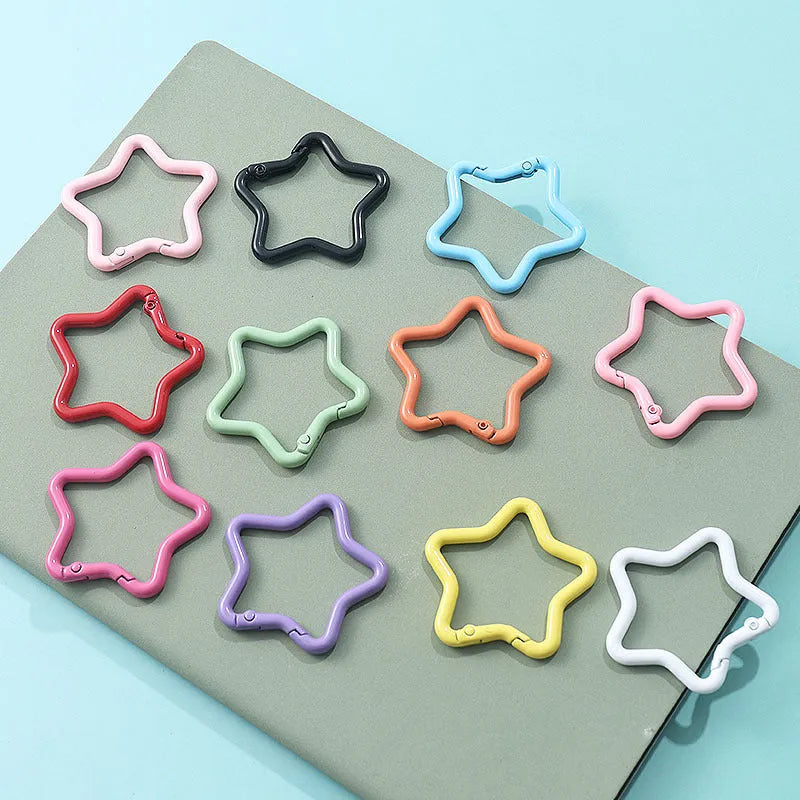 Zinc alloy five-pointed star keychain charm in multiple colour options on a white background.