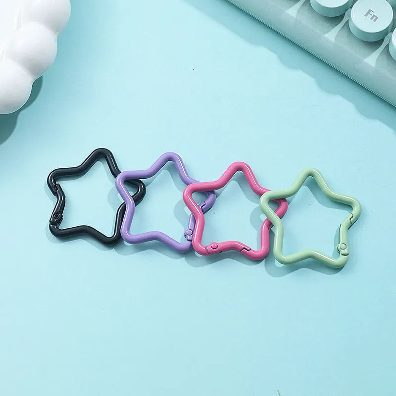 Zinc alloy five-pointed star keychain charm in multiple colour options on a white background.