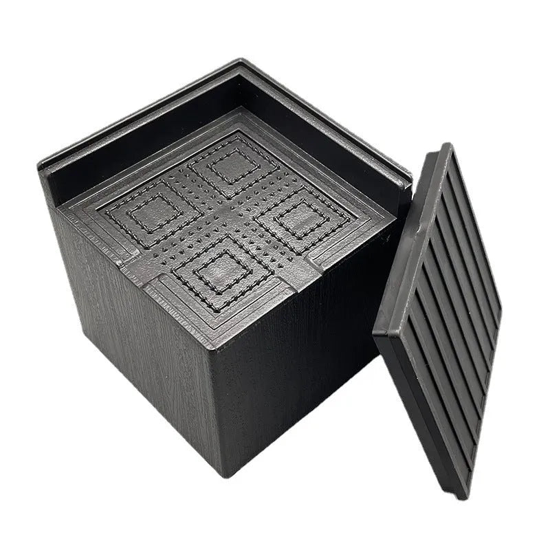 Four black plastic furniture foot mats for height adjustment and floor protection