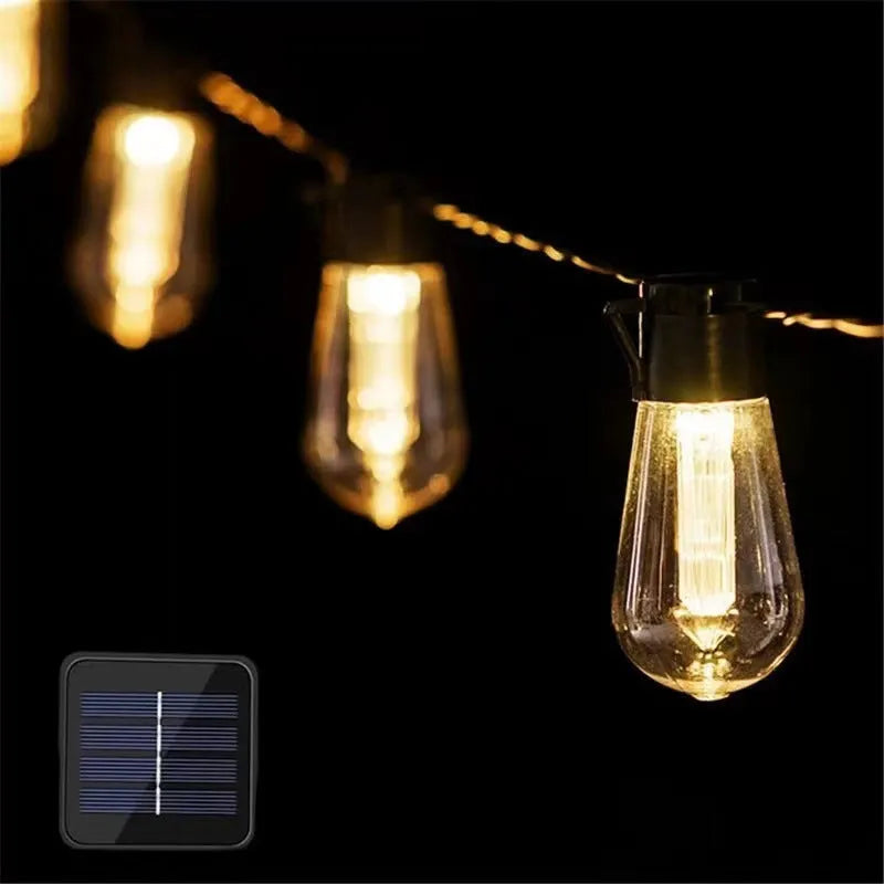 Outdoor retro long bulb infusion bottle shape string lights hanging in a garden setting.