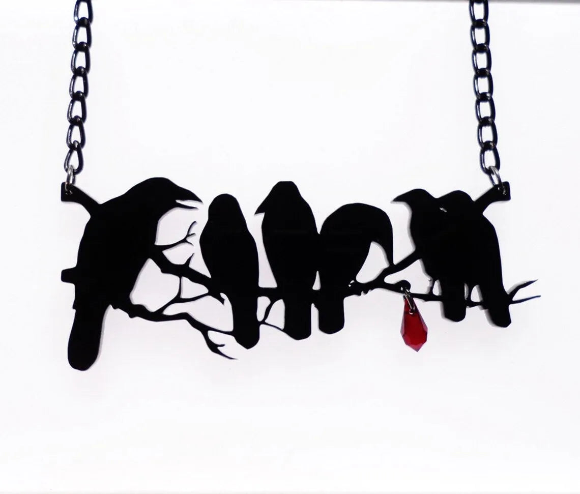 Black alloy crow pendant necklace on a cross chain for women, gothic bird motif jewellery.