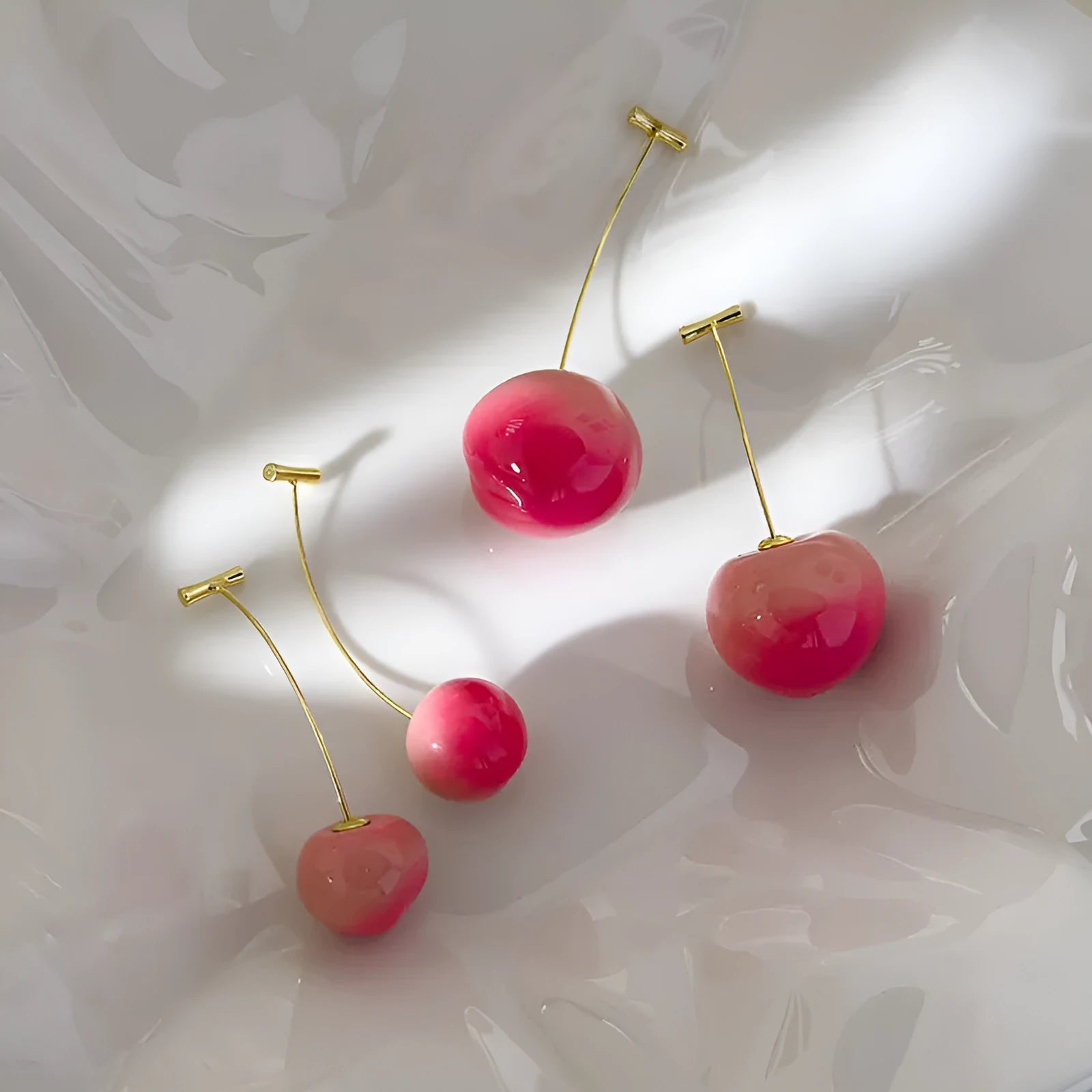 A pair of women's acrylic earrings shaped like juicy peaches, shown in small and large size options.