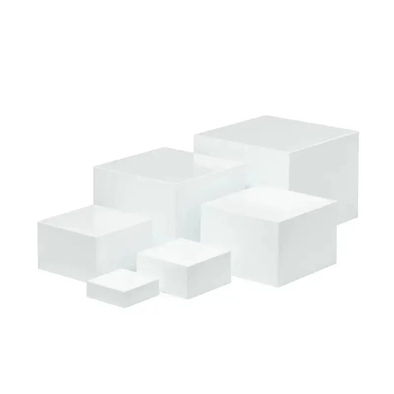 Six white geometric cube dessert display stands arranged on a table.