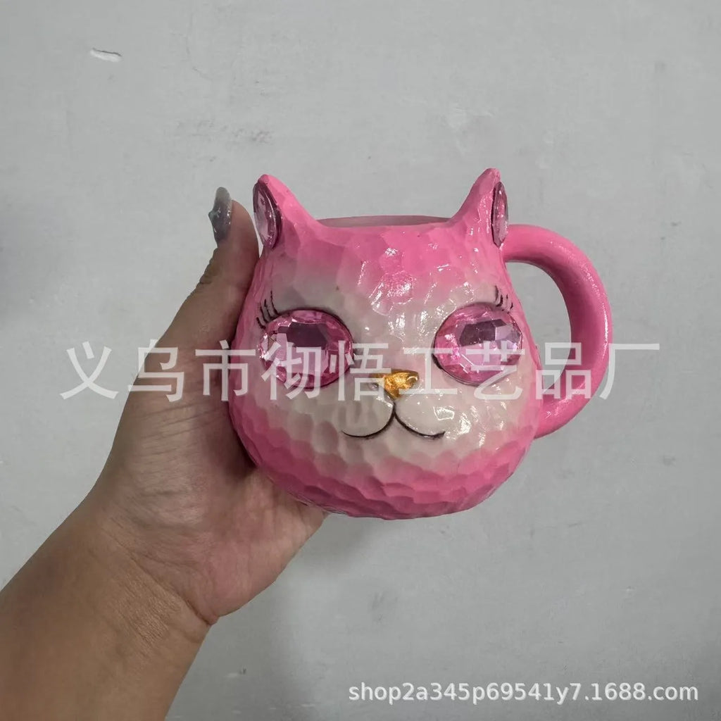 Colourful resin cat cup figurine on a shelf, shown in purple, green, blue, and pink colour options.