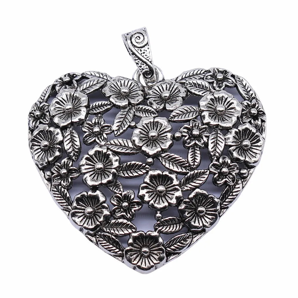 Ancient silver hollow flower love symbol alloy pendant on a dark background.
