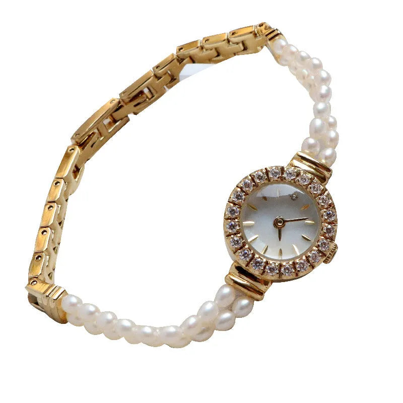 Light gold women's bracelet watch with freshwater pearls and an 18mm round dial on a stainless steel strap.