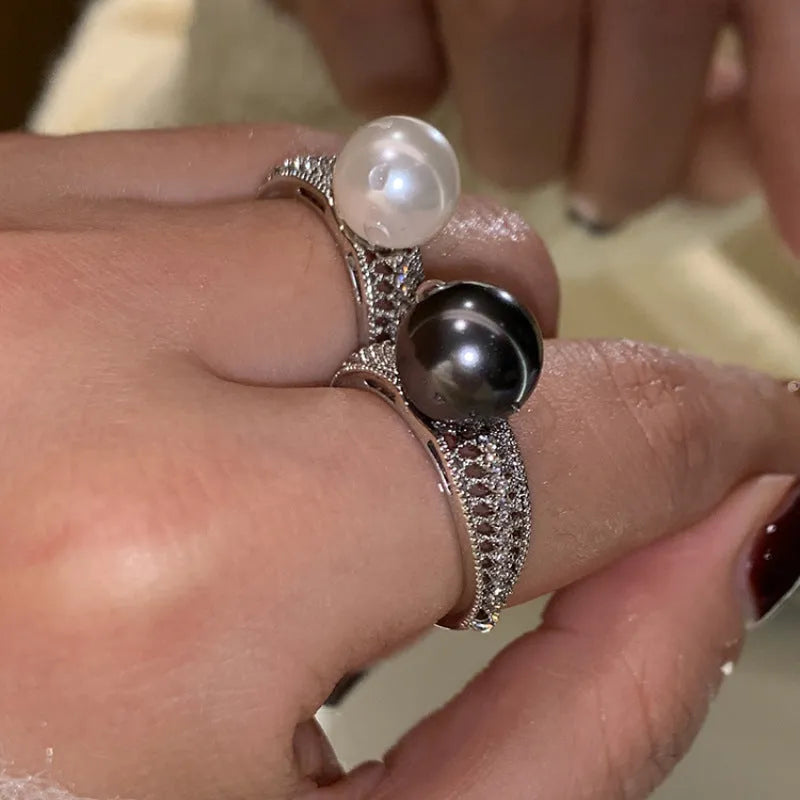 Geometric copper adjustable ring with a black pearl for women, shown on an index finger.