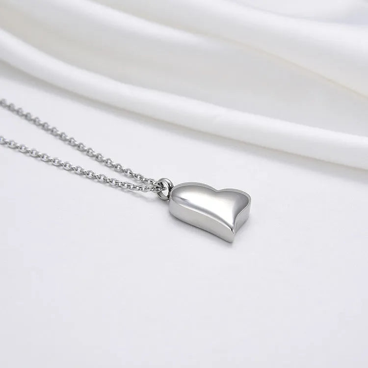 Silver curved peach heart pendant on a stainless steel necklace with an extension chain.