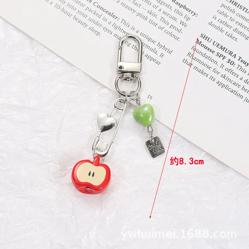 Fruit-themed mobile phone charm keychain with apple and strawberry designs in plastic/resin construction