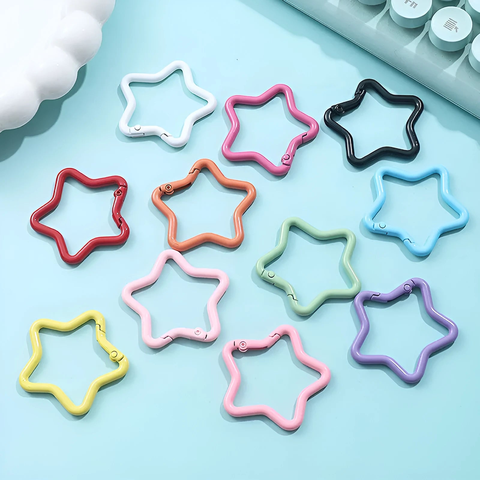 Zinc alloy five-pointed star keychain charm in multiple colour options on a white background.