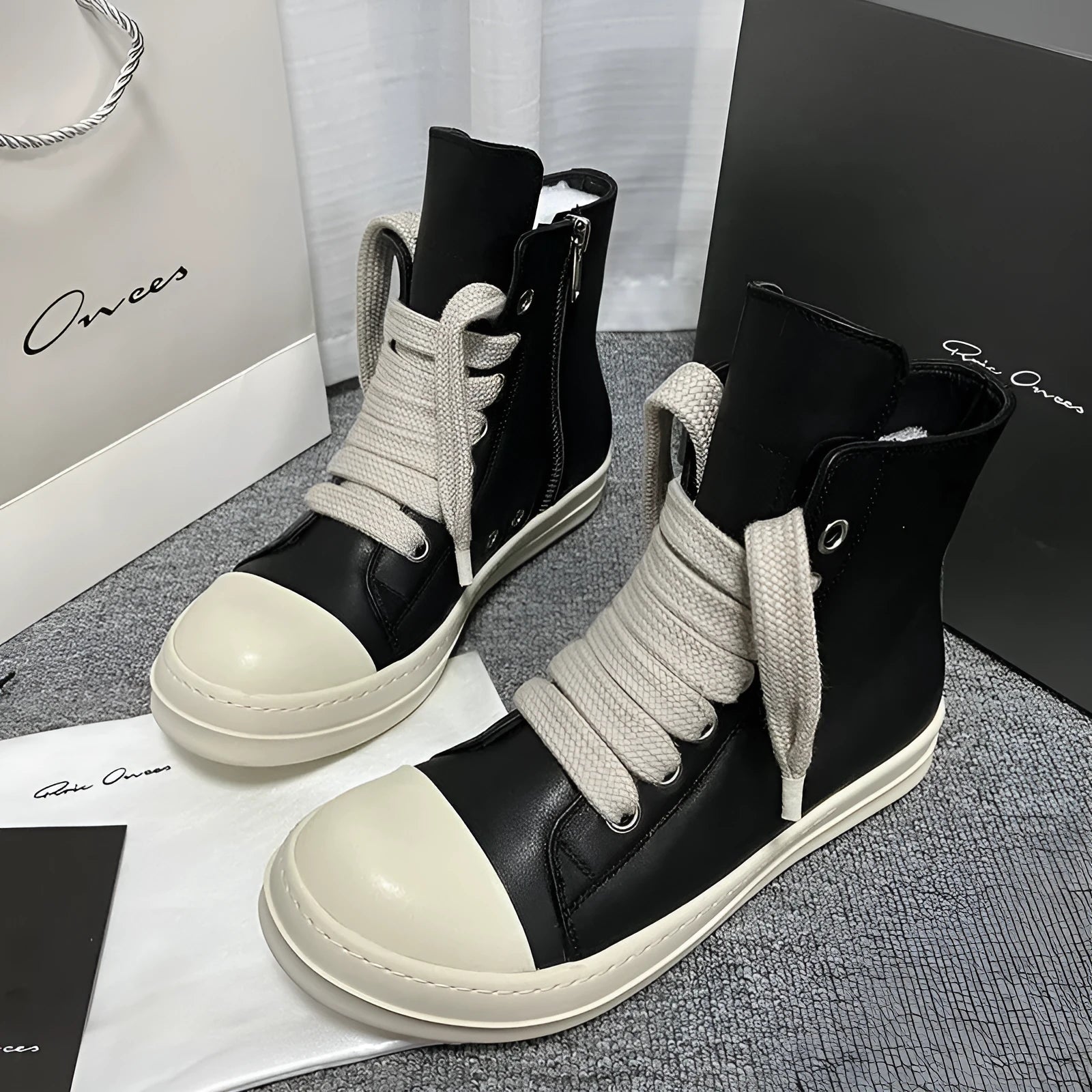 Black leather high-top sneakers with side zipper and round toe on a rubber platform sole