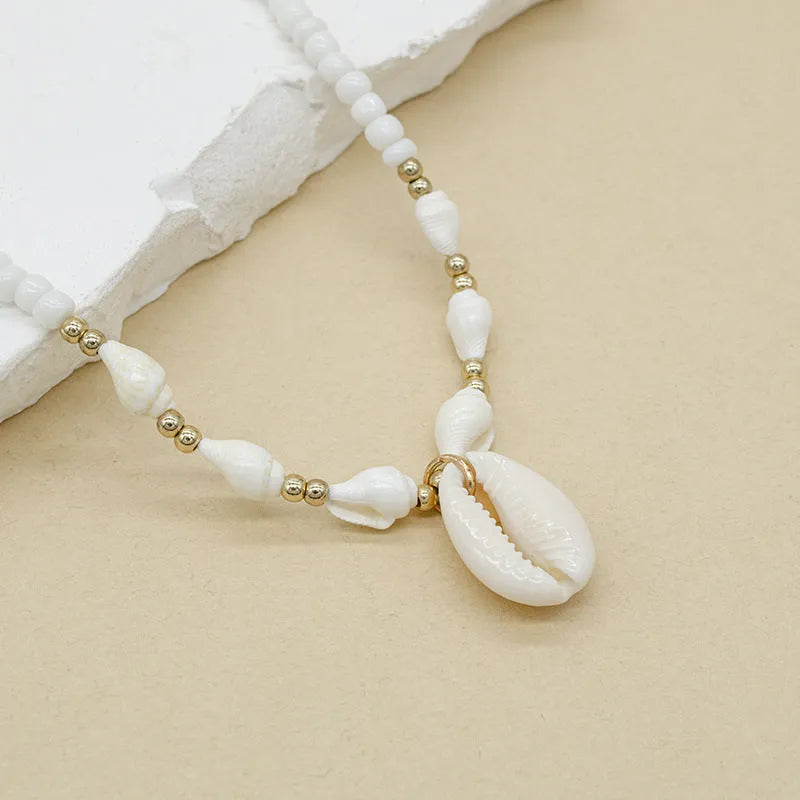 White conch shell necklace with mother-of-pearl pendant on electroplated chain with bead accents