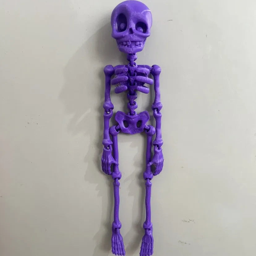 3D printed white skull refrigerator magnet with intricate details on a metallic surface.