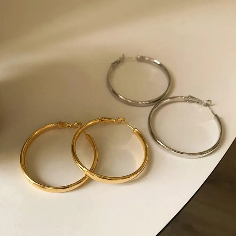 Large circular gold and silver metal hoop earrings measuring 40mm