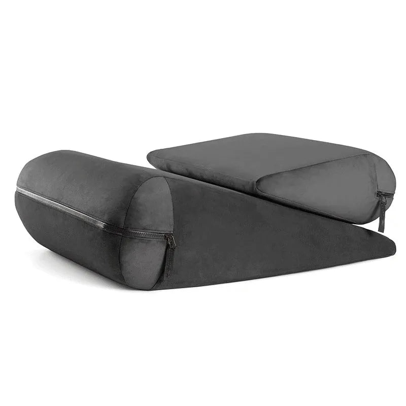 A grey embroidered triangular wedge cushion on a chair, showing its 68cm length and 25cm height for back support.