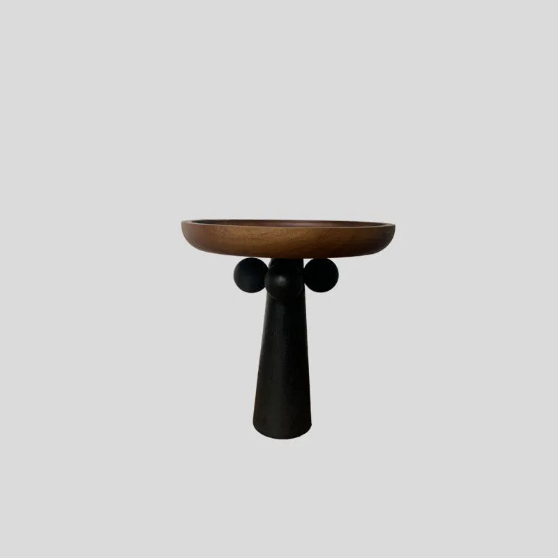 Round high-legged wooden tray in modern style holding a candle and perfume bottle for home decor.