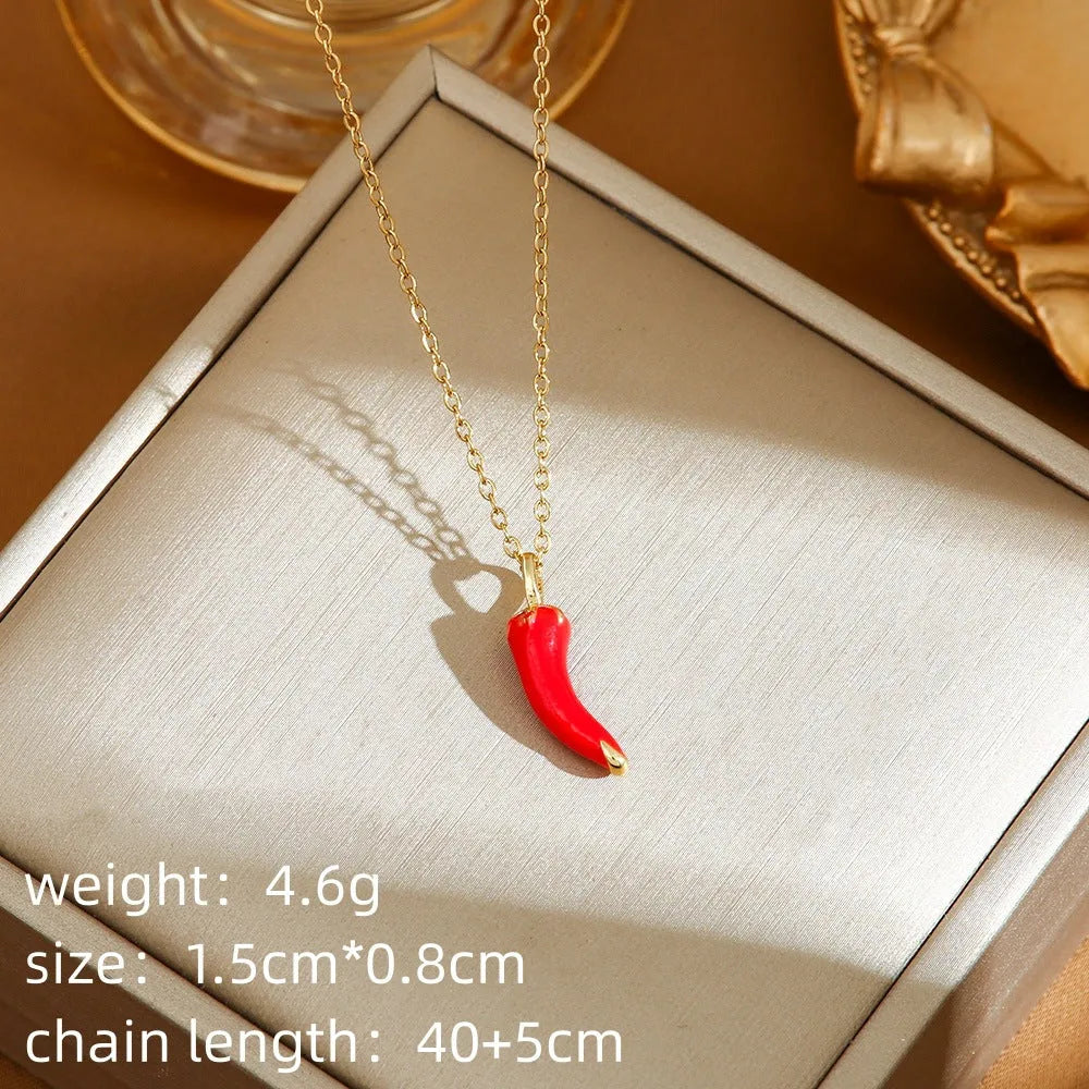 Golden strawberry charm on a titanium steel O-ring chain necklace.