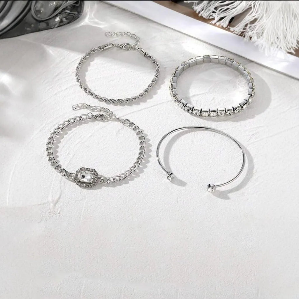 Gold and silver alloy square diamond geometric jewellery set with bracelet and pendant on a white background.