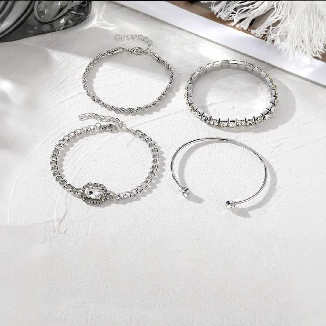 Gold and silver alloy square diamond geometric jewellery set with bracelet and pendant on a white background.