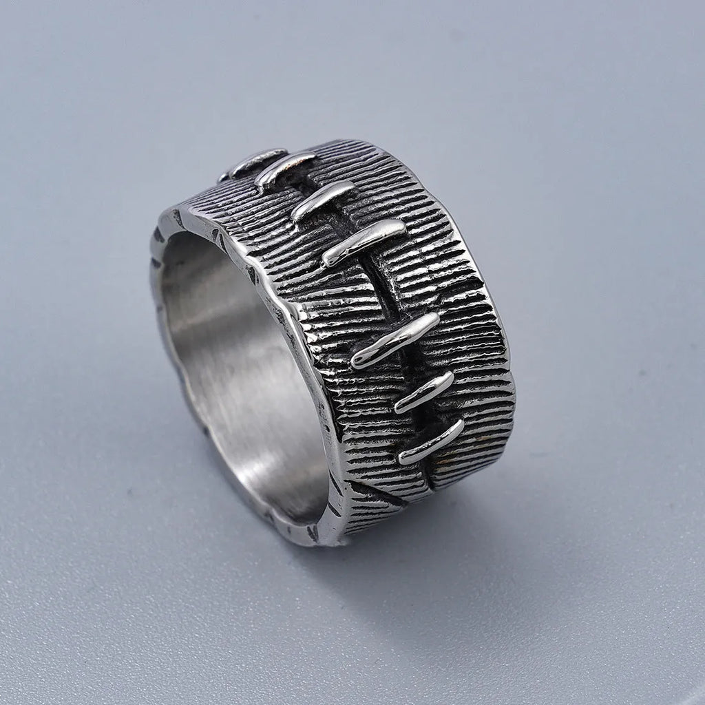 A dark geometric titanium steel ring with punk stitching and a double ring design on a grey background.